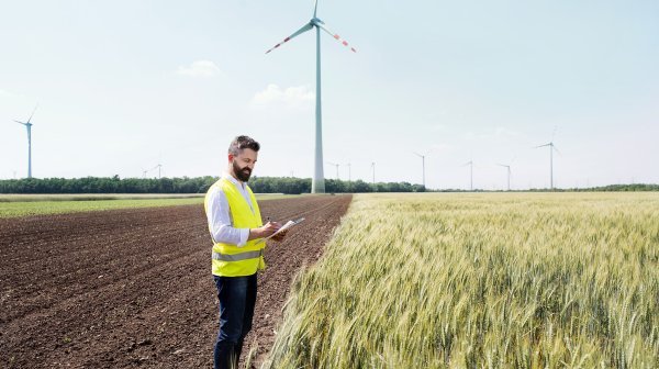 Mann steht im Feld mit iPad