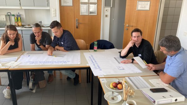 5 Personen arbeiten in Kleingruppen