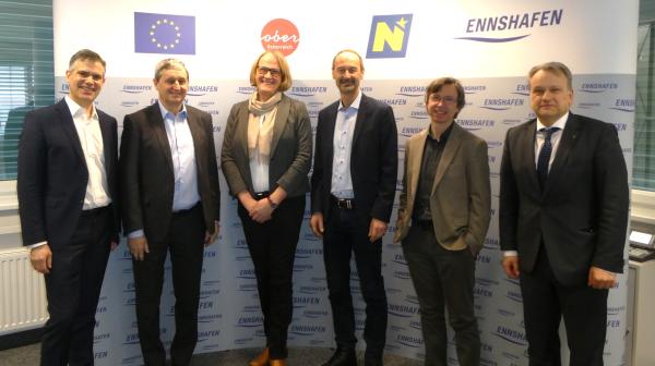 Gruppenfoto mit 5 Herren und einer Frau vor Ennshafen Rückwand