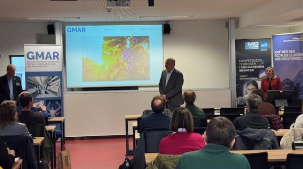 Mann hält eine Präsentation mit PowerPoint vor einer kleinen Gruppe