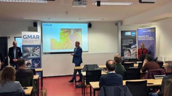 Mann hält Präsentation mit PowerPoint vor kleiner Gruppe