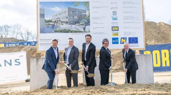 fünf Personen stehen nebeneinander und haben einen Spaten in der Hand