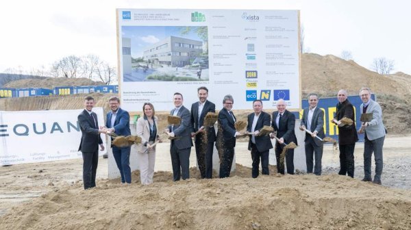 Personen stehen nebeneinander und haben einen Spaten in der Hand