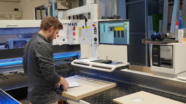 Mann steht vor Computer um Prozesse zu optimieren