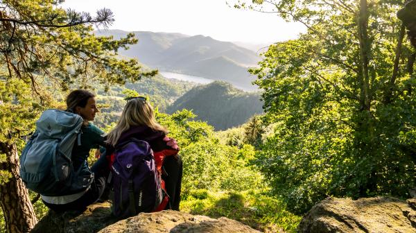 Zwei Frauen sitzen auf Granitfelsen auf Hügeln mit Blick zum Donauflussrhalb der Donau