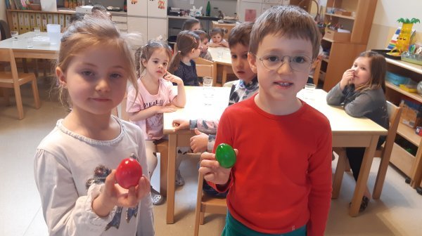 Zwei Kinder mit bunten Eiern in der Hand
