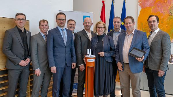 Personenfoto mit 8 Männern rund um Landeshauptfrau Mikl-Leitner