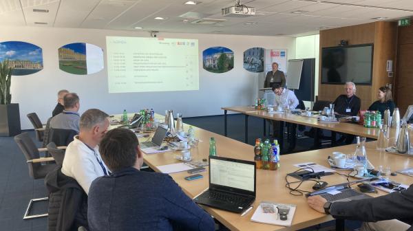 Mehrere Menschen sitzen beim Projektmeeting in einem Workshopraum