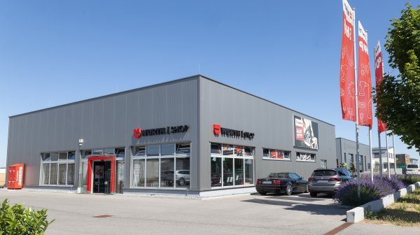 Außenansicht der Firma Würth mit Fahnen und Parkplatz im Wirtschaftspark Mistelbach