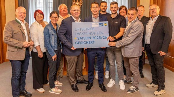 Personenfoto mit 1^2 Personen und einer Tafel