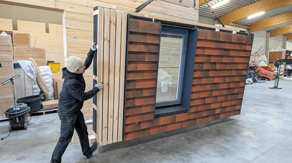 Mann transportiert vorgefertigte Fassade