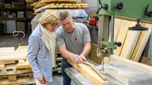 Zwei Personen in einer Tischlerei beim Informieren zu den Arbeitsschritten