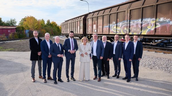 Großes Gruppenfoto vor neu verlegten Bahngleisen mit 2 Bahnwaggons