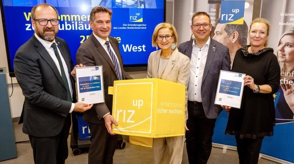 Fünf Personen mit RIZ UP Würfel und Jubiläumstafeln in der Hand