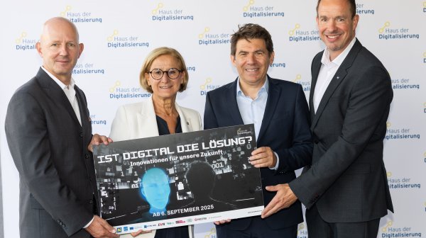 Vier Personen halten Tafel mit "Ist Digital die Lösung" in der Hand
