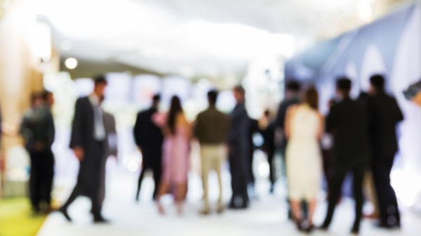 mehrere Personen, die in einem Gang stehen. Das Bild ist verschwommen.