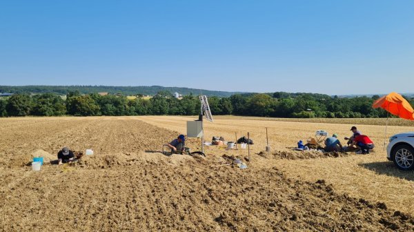 Menschen am Feld mit Forschungsstation