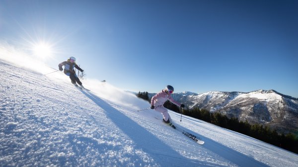 Zwei Skifahrer im Carving-Style auf der Skipiste in Lackenhof