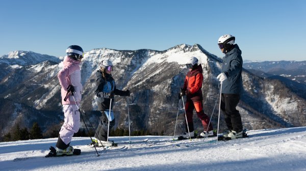 Vier Skifahrer in Lackenhof auf der Piste stehend