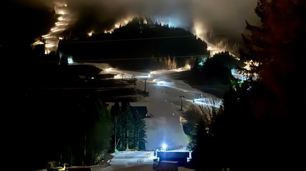 Skigebiet Annaberg im Dunkeln mit beschneiten Pisten im Flutlicht