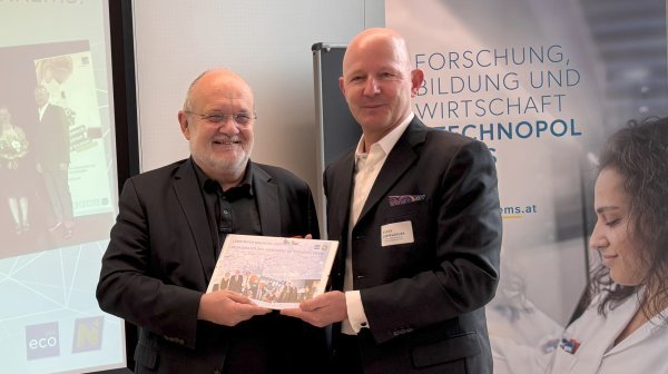 Zwei Personen fotografiert vor Roll-up