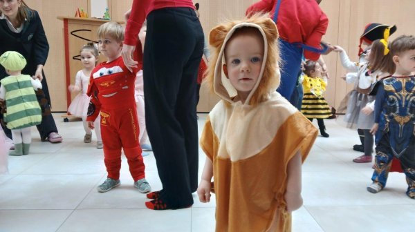 Ein IZIBIZI Kind als kleiner Löwe verkleidet im Hintergrund weitere verkleidete Kinder 