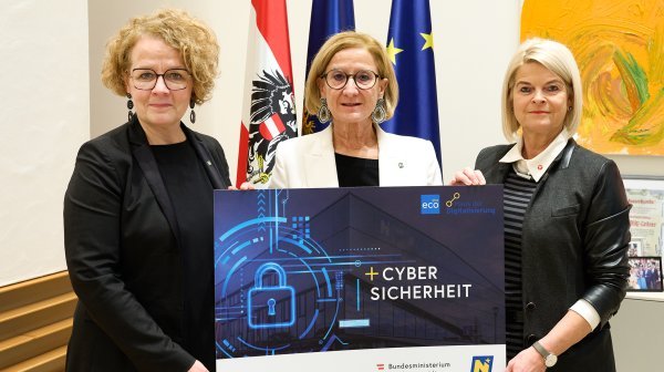 Drei Frauen halten eine Pressetafel mit Cyber Sicherheit in die Kamera