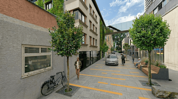 wenig befahrene Wohnstraße einer Innenstadt, begrünt und mit Sitzgelegenheiten