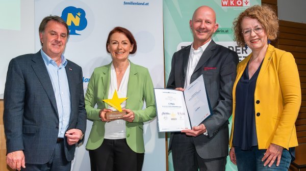 Vier Personen bei einer Prämierungsfeier mit Stern und Urkunde in der Hand