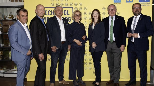 Acht Personen vor gelber Langer Nacht der Forschung Wand