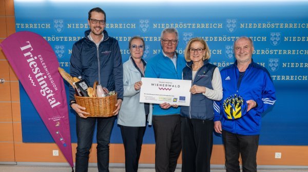 Fünf Personen stehen vor einer blauen Wand.