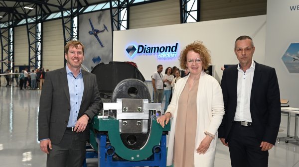Drei Personen stehen in Halle von Diamond Aircraft
