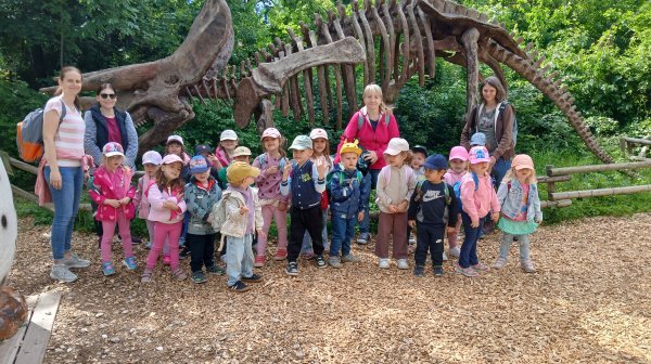 Kindergartenkinder vor einem großen Dinoskelett 
