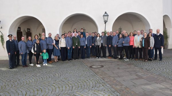 Ganz große Personengruppe steht im Innenhof eines Schlosses