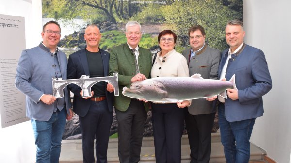 Sechs Personen halten Papp-Attrappen eines Fisches und einer Brücke