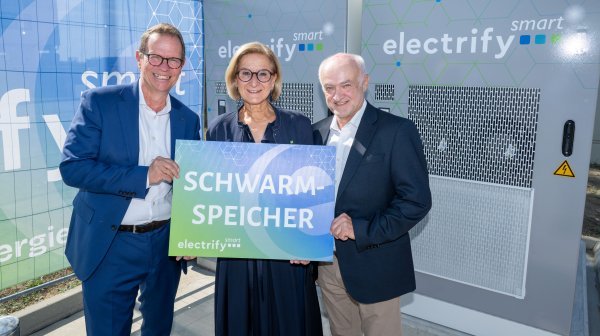 Drei Personen halten Tafel mit Schriftzug Schwarmspeicher in die Kamera