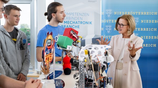 Jugendliche präsentieren Robotermodelle bei einer Veranstaltung 