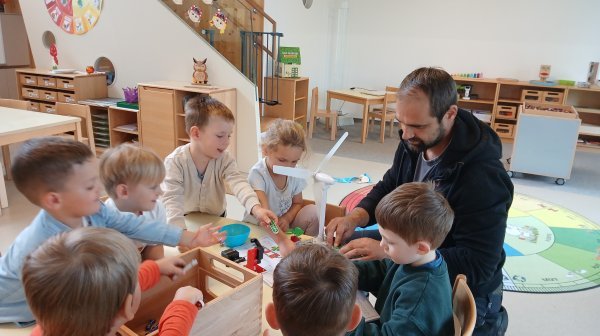 Kindergartenkinder experimentieren mit einem Tischwindrad