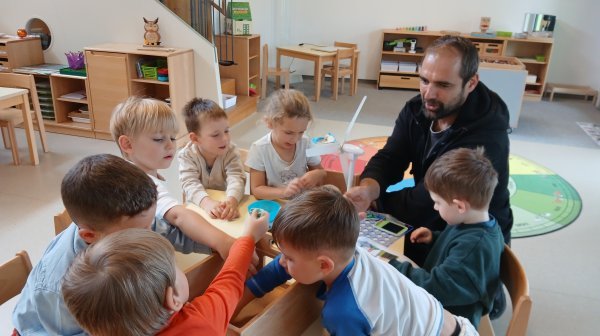 Kindergartenkinder entdecken mit einem Tischwindrad wie Windkraft genutzt werden kann