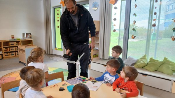 Kindergarten beim Experimentieren mit einem Föhn und einem Windrad
