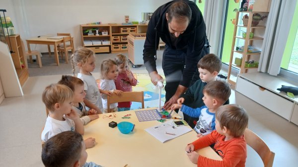 Kindergartenkinder beim Experimentieren mit einem kleinen Tischwindrad