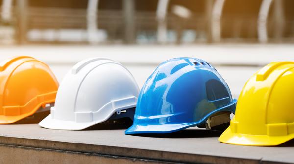 Mehrfarbige Sicherheitshelme von Bauarbeiterinnen und Bauarbeitern