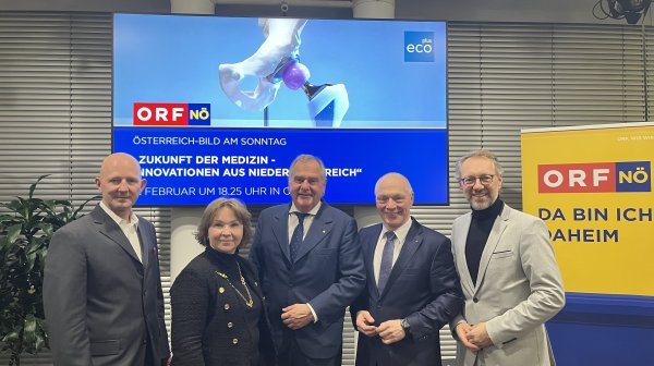 Fünf Personen stehen vor Leinwand