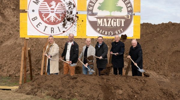 Sechs Personen mit Schaufeln beim Spatenstich der Baustelle