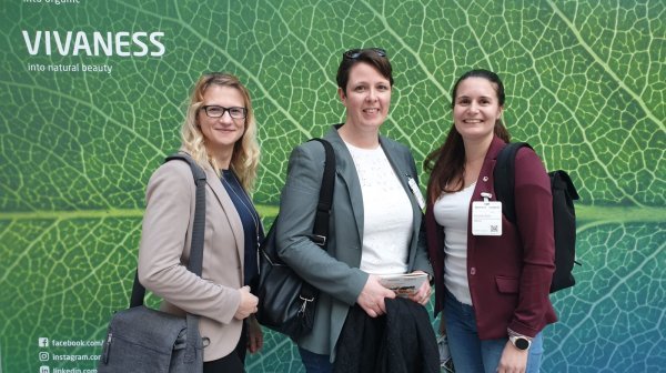 Drei Frauen vor Werbewand