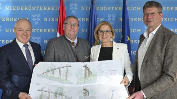 Vier Personen halten einen Bauplan