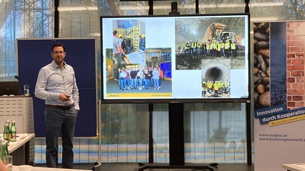 Mann steht neben Bildschirm mit Präsentation