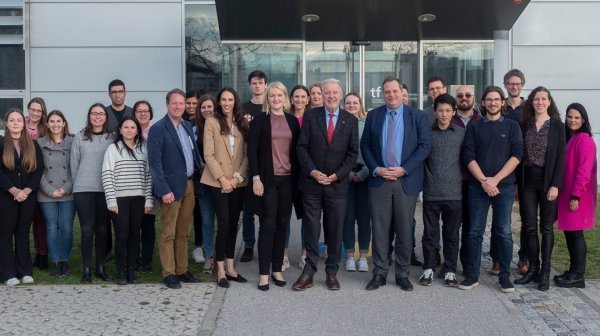 Mehrere Personen stehen vor Gebäudeeingang