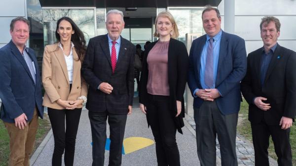 Sechs Personen stehen nebeneinander vor Gebäudeeingang