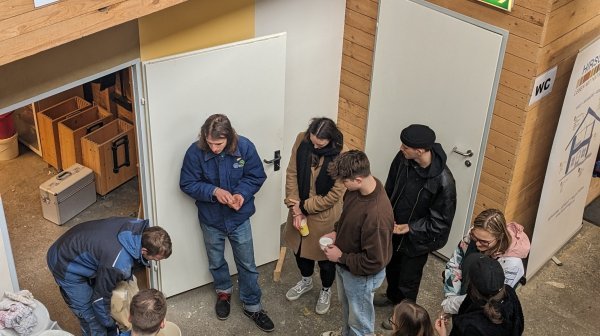 Mehrere Personen stehen in einem Kreis